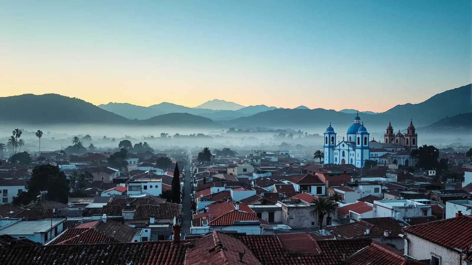 Morgendliches Panorama über die Dächer einer Andenstadt, blaue Kuppeln fangen das erste Licht.