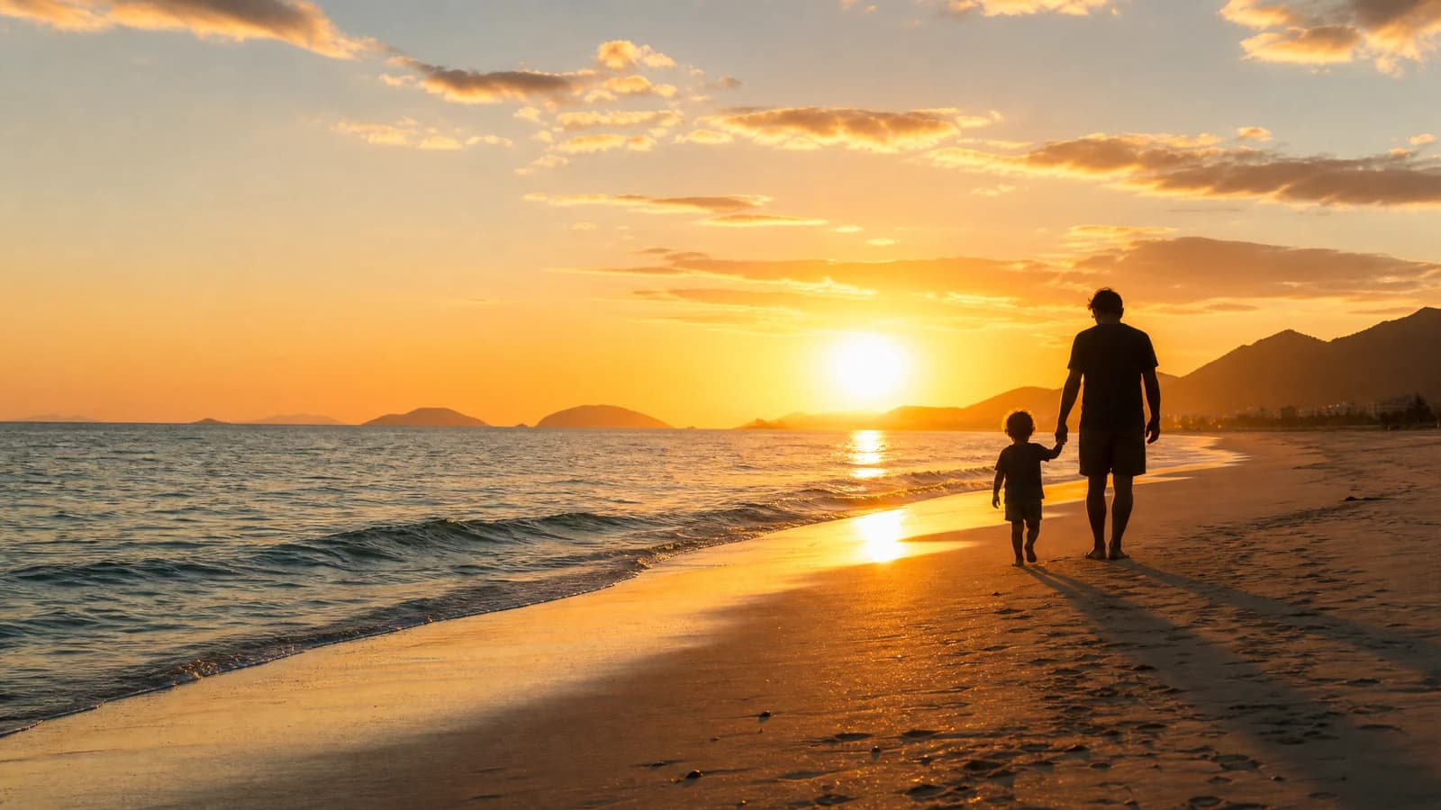 Elternteil und Kind gehen Hand in Hand am Strand von Florianópolis im Abendlicht